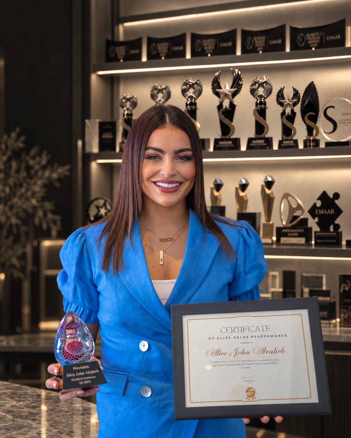 Alice holding her Elite Sales Performance certificate and trophy